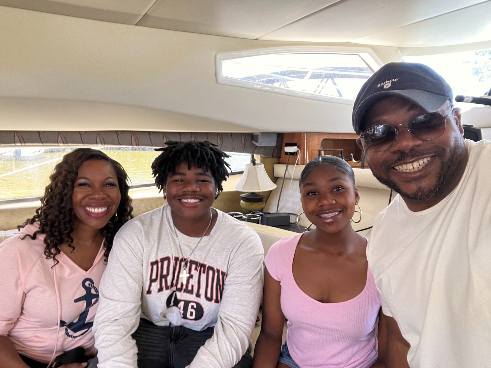 Family of four smiling together inside their boat